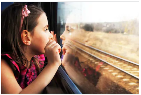Little girl looking out train window